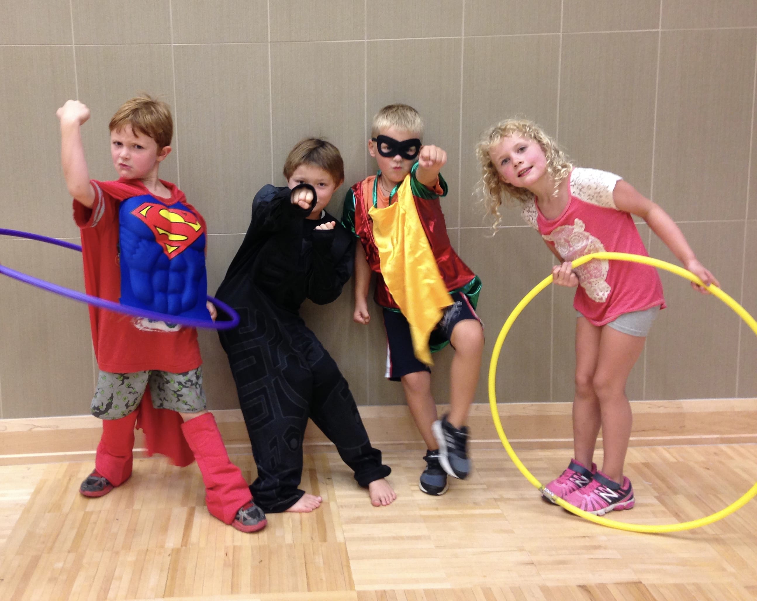 Four children posing as super heroes