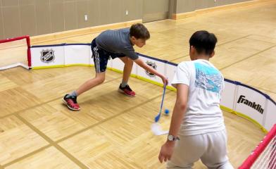 Kids playing mini sticks at the Community Centre