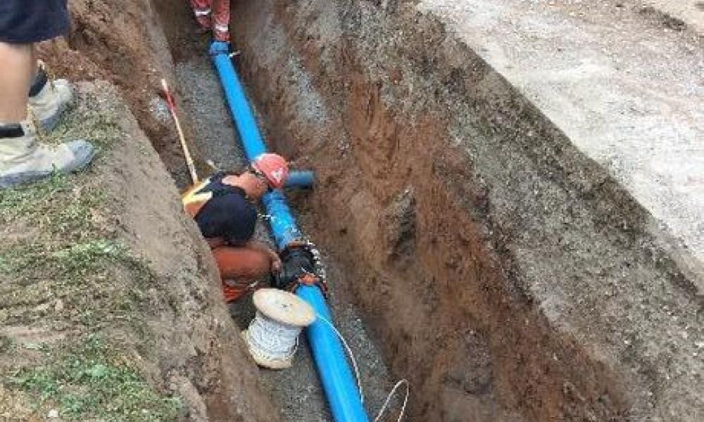 Engineers putting a pipe in a trench