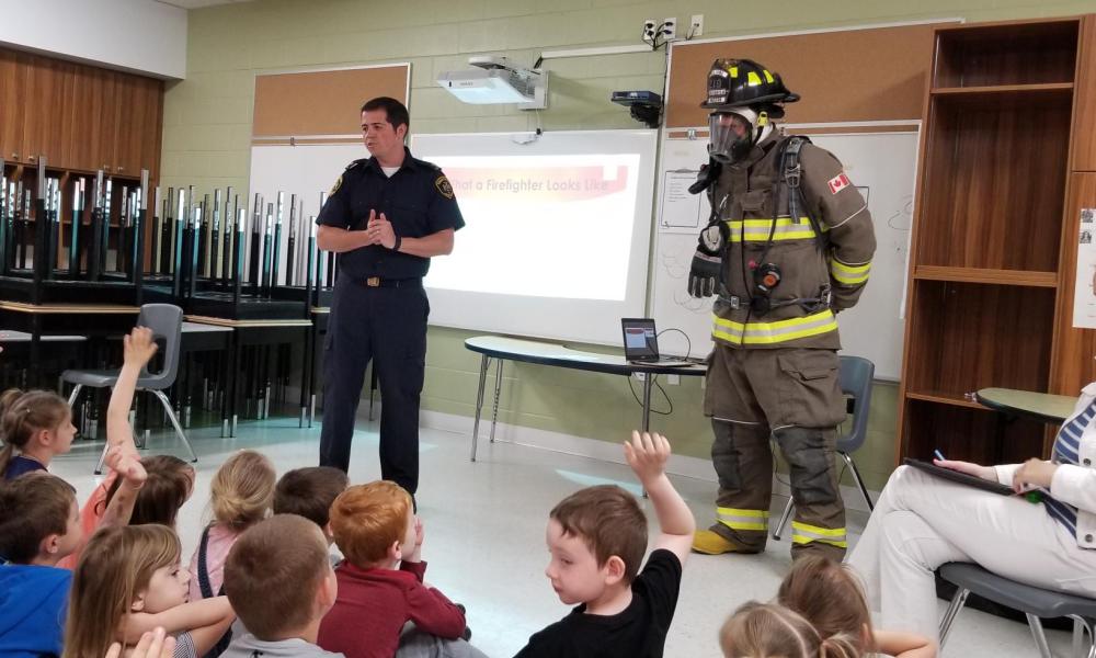 Firefighter teaching kids in a classroom