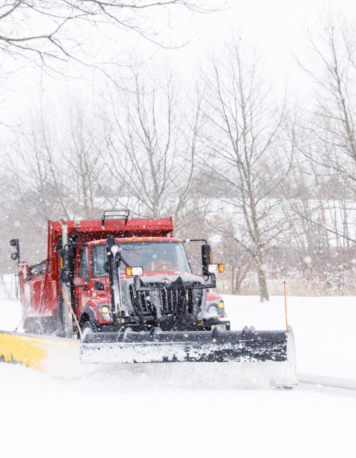 Red snow plow clearing a road