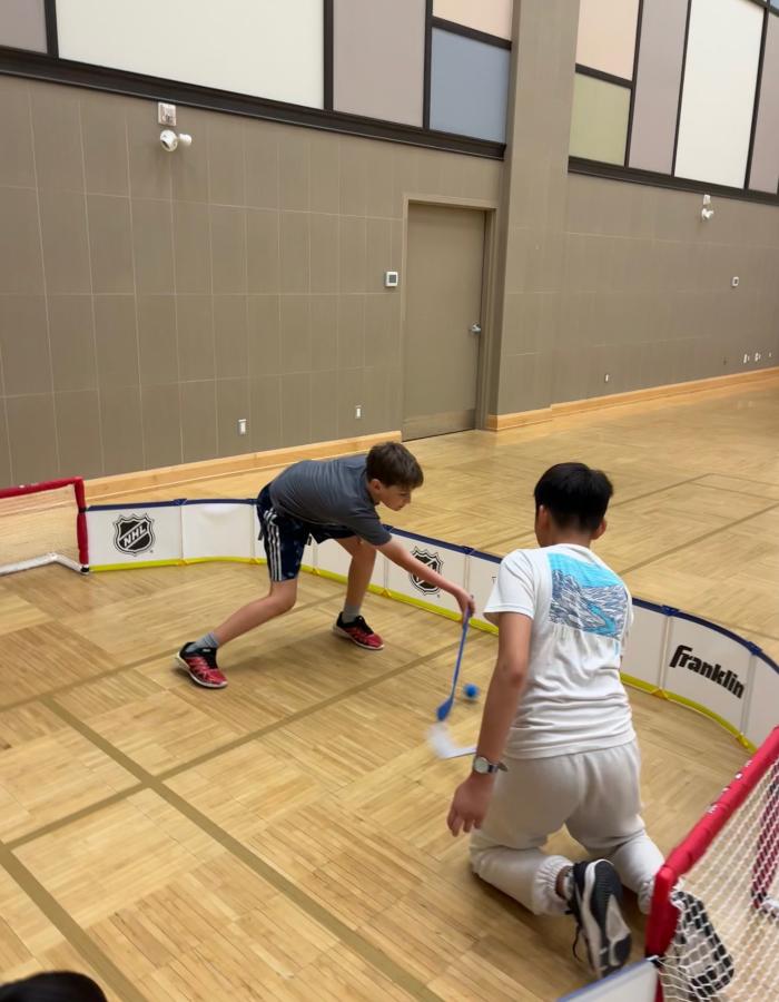 Kids playing mini sticks at eh Community Centre