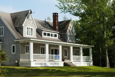Front of a house with a large tree in front