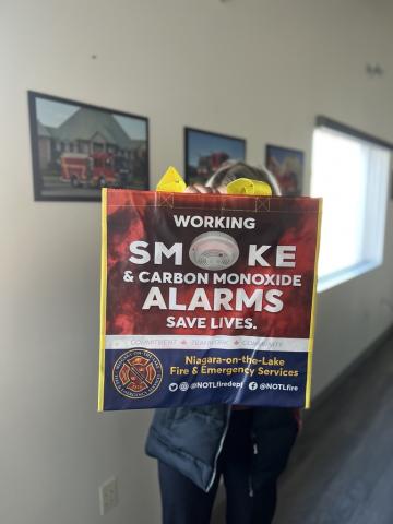 Image of reusable bags with messaging "working smoke & carbon monoxide alarms save lives".